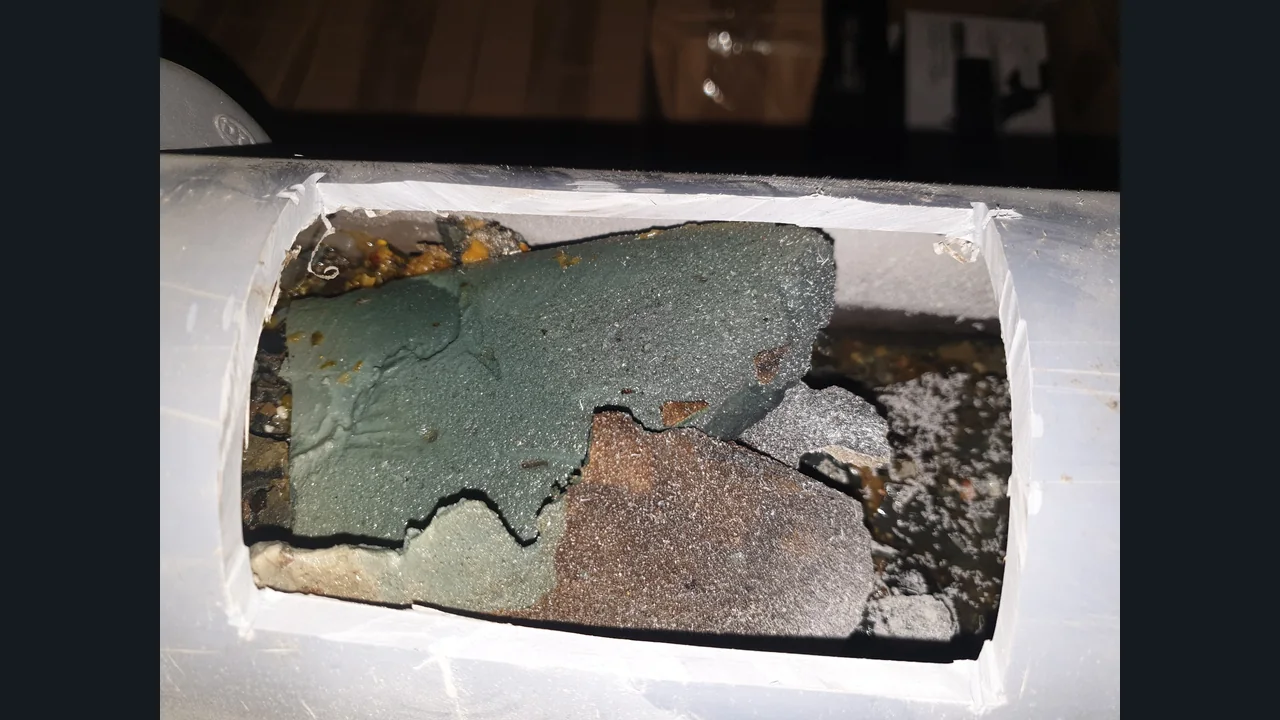 잘라낸 배관 내부를 가로막고 있는 굳은 시멘트 덩어리